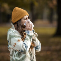 Woman sneezing in need of springtime allergy remedies